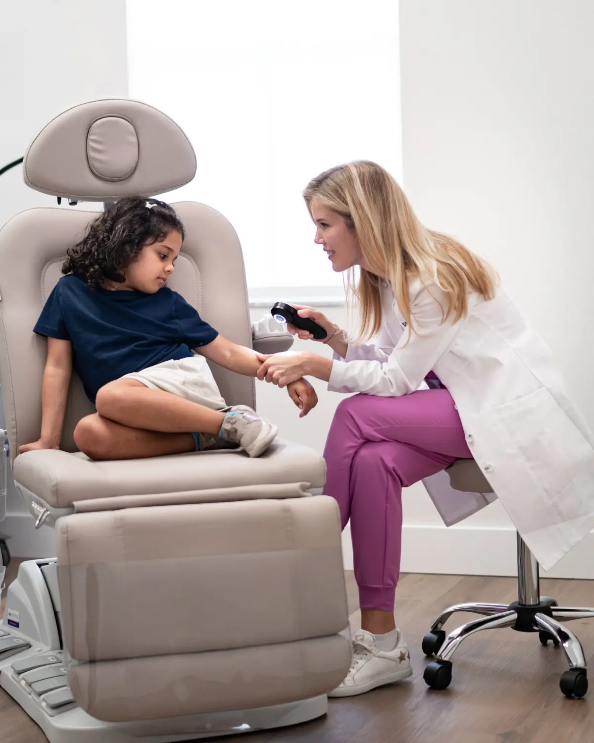Dr. Alexandra Grob with a young patient during a pediatric dermatology visit